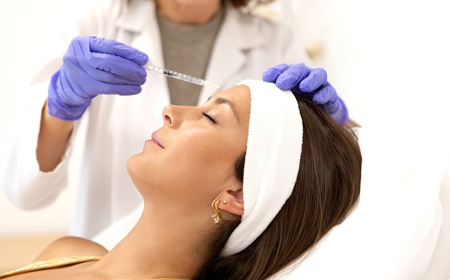 Woman receiving cosmetic injection treatment at clinic.